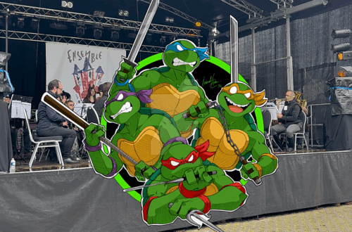 Musiciens de l’Ensemble Instrumental Waremmien en concert à Trolls & Légendes, avec une illustration des Tortues Ninja en superposition sur la scène.