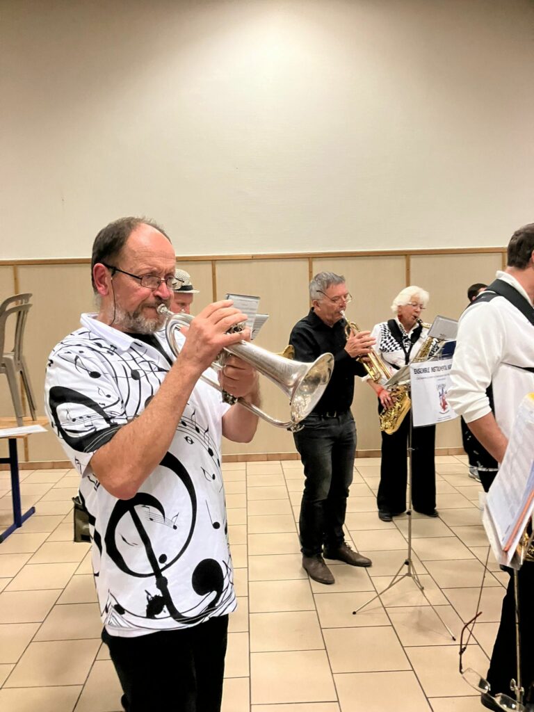 Musiciens trompettistes de l’Ensemble Instrumental Waremmien en tenue décorée de symboles musicaux lors du Concert Bestial à Tilleur