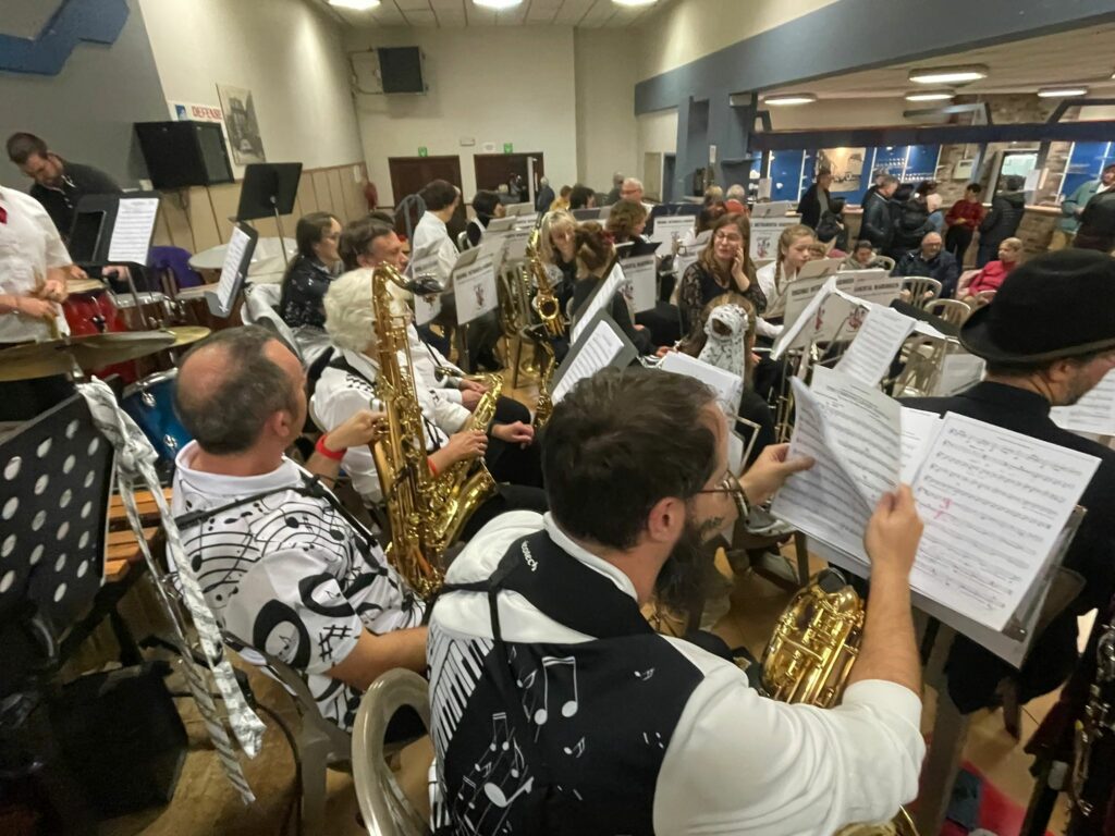 Musiciens de l’Ensemble Instrumental Waremmien en tenue blanche et noire préparant le Concert Bestial au centre culturel de Tilleur