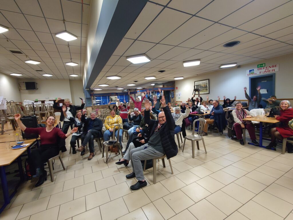 Public enthousiaste levant les bras lors du Concert Bestial de l’Ensemble Instrumental Waremmien au centre culturel de Tilleur à Saint-Nicolas